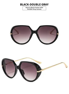 Detail of oversized black sunglasses with metal temples and gradient gray lenses