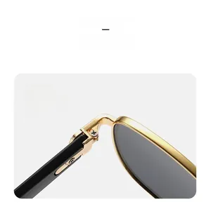 Detail of sturdy metal hinge and golden frame on vintage square men's sunglasses