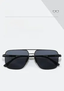 Close-up of classic black double-bridge aviator sunglasses with metal frame and grey lenses