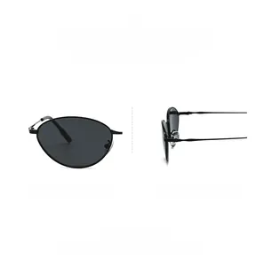 Détail de lunettes de soleil ovales en métal noir avec branches fines et verres foncés