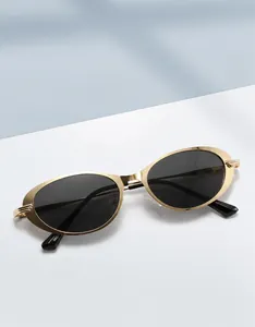 Détail de lunettes de soleil ovales en métal doré avec verres noirs et plaquettes de nez