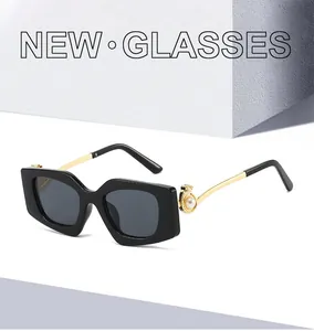 Detail view of square frame sunglasses with gold metal temples and pearl accents