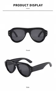 Detailansicht der dicken schwarzen Sonnenbrille mit Metallnieten und grauen Gläsern