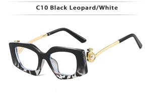 Detail of square glasses with gold leopard head relief and white pearl inlay