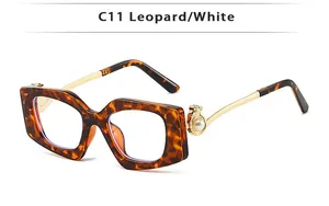 Detail of leopard print sunglasses featuring a gold leopard head and pearl temple accent