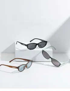 Detail view of oval frame sunglasses in black, mint green, and amber with metal temple bars