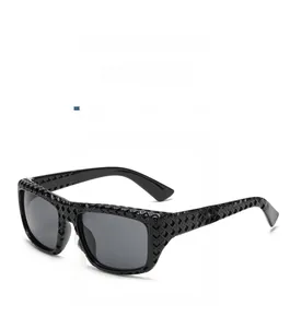 Détail de lunettes de soleil carrées noires avec monture à texture géométrique 3D creuse