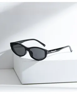 Detail of black sunglasses with silver metallic temple accents on a white display pedestal