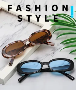 Detailed view of tortoise shell and black oval frame sunglasses on a marble surface
