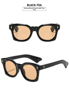 Vue détaillée de lunettes de soleil rétro noir brillant avec verres thé et rivets dorés