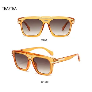 Détail de lunettes de soleil carrées thé avec bordure dorée et verres dégradés