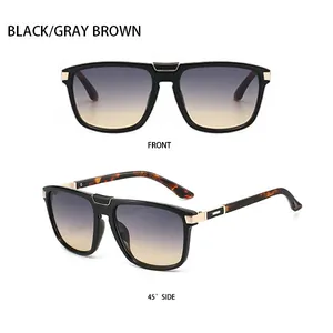 Close-up of black aviator sunglasses with gold metal hinges and gradient brown lenses
