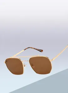 Detail of gold polygonal double bridge sunglasses with brown lenses and metal frame