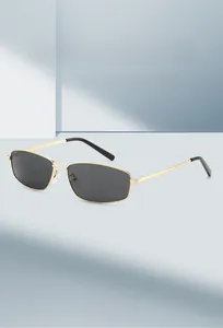 Detail of slim gold metal frame sunglasses with rectangular dark grey lenses and nose pads