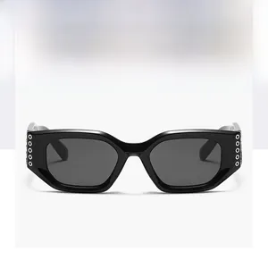 Détail de lunettes de soleil rectangulaires noires avec rivets métalliques sur les charnières