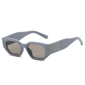 Lunettes de soleil carrées chics avec verres gris fumé et rivets métalliques latéraux