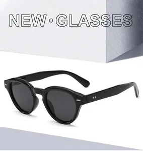 Detail of vintage round black sunglasses with metallic rivet accents and glossy finish