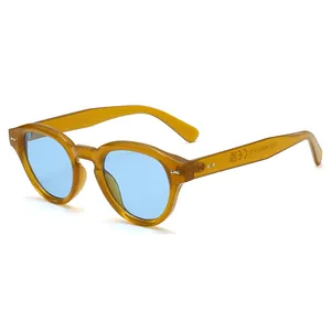 Retro amber round frame sunglasses with light blue lenses and silver rivets at 45 degree angle
