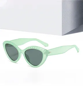 Détail de lunettes de soleil œil-de-chat vert menthe avec rivets et verres gris