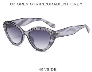 Détail de lunettes de soleil œil de chat rayées grises avec rivets et verres dégradés