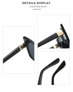 Detailed close-up of wide black cat-eye sunglasses with reinforced gold metal hinges