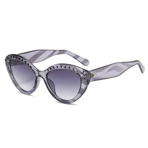 Lunettes de soleil œil de chat gris transparent avec monture cloutée pour femme