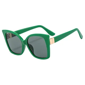 Stylish oversized green cat-eye sunglasses with dark grey lenses and gold metal accents
