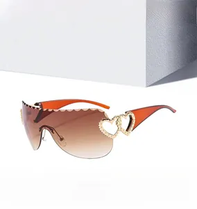 Détail de lunettes de soleil orange avec charnières cœurs dorés et verres dégradés