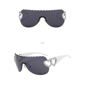 Détail de lunettes Y2K grises avec ornements de cœur en métal argenté et branches blanches
