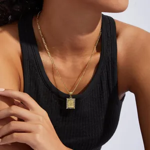 Detailansicht einer vergoldeten Figaro-Kette mit rechteckigem Kreuzanhänger für Damen