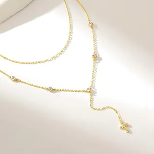 Close-up of a gold Y-shaped necklace featuring sparkling zircons and a cross pendant