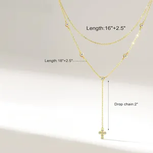 Macro detail of Y-shaped double layer gold necklace with cross pendant and crystal accents