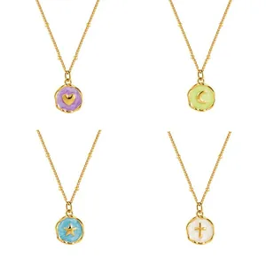 Detail of brass gold-plated pendants with enamel heart, star, and moon patterns