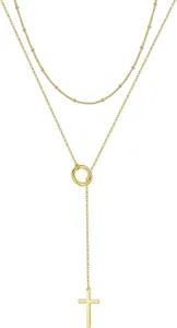 Detail of a gold double-layer necklace featuring small beads and a cross pendant on a Y-chain