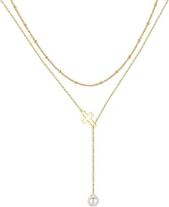 Detail of layered gold Y-necklace featuring a hollow cross and elegant pearl drop