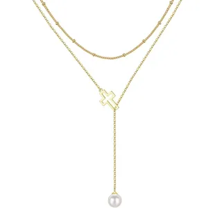 Double layered gold Y-necklace with cross pendant and white pearl drop on white background
