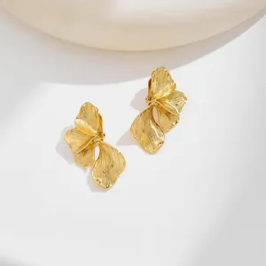 Detailed shot of golden flower petal earrings with textured metallic finish and elegant curves