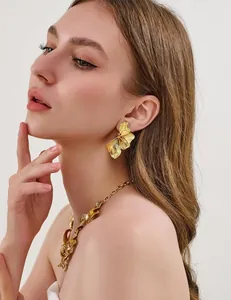 Detail of gold floral jewelry set with textured petals on necklace and earrings