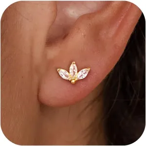 Détail d'une boucle d'oreille papillon dorée avec des zircons scintillants taille marquise