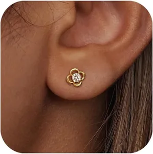 Gros plan d'une boucle d'oreille fleur en or avec zircon blanc portée sur le lobe