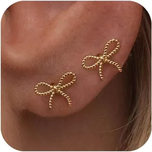 Vue macro de boucles d'oreilles papillon dorées torsadées portées sur le lobe