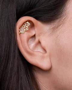 Close-up of golden mandala lotus ear cuff with intricate hollow design on human ear