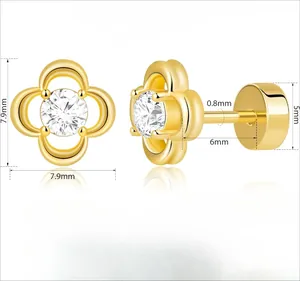 Détail de boucles d'oreilles trèfle doré avec zircone et fermoir de sécurité à vis