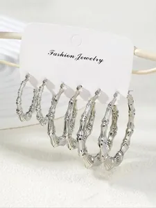 Detailed view of silver bamboo hoop earrings in three sizes on a fashion display card