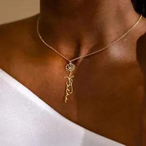 Close-up of personalized gold flower name necklace featuring Sasha engraving on a model