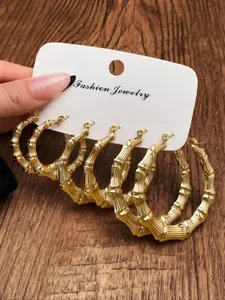 Detailed view of three pairs of golden bamboo-style hoop earrings in different sizes