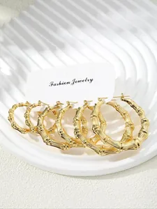 Three pairs of gold bamboo-textured hoop earrings displayed on a fashion jewelry card
