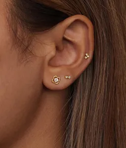 Gros plan de boucles d'oreilles papillon dorées minimalistes serties de zircon