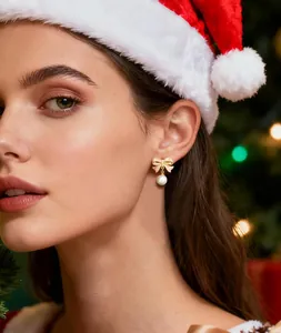 Primer plano de pendientes de lazo rosa con perla blanca en un ambiente navideño festivo