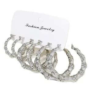 Three-pair set of silver bamboo-textured hoop earrings displayed on a white card
